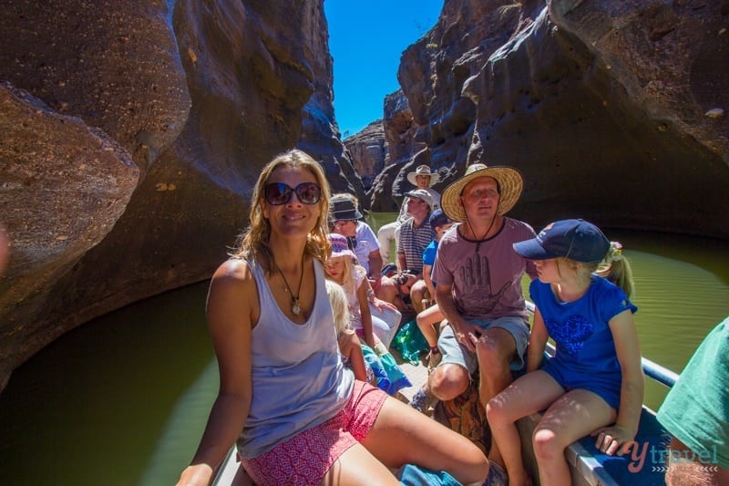 people sitting on a boat through a canyon