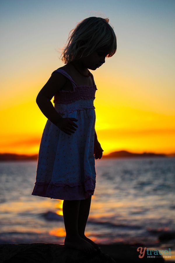 Sunset silhouette of girl at Rainbow Bay - 