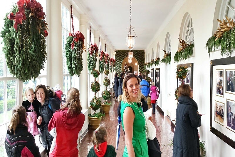 people walking through a hallway decorated for Christmas