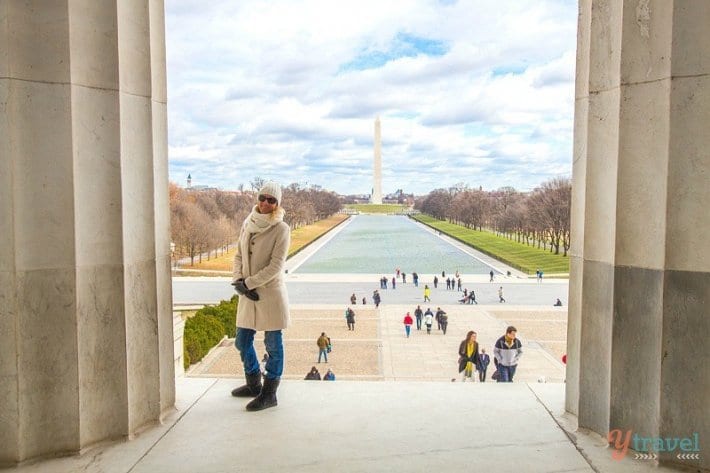 woman standing inside the Abraham Lincoln Memorial with views of washington monument