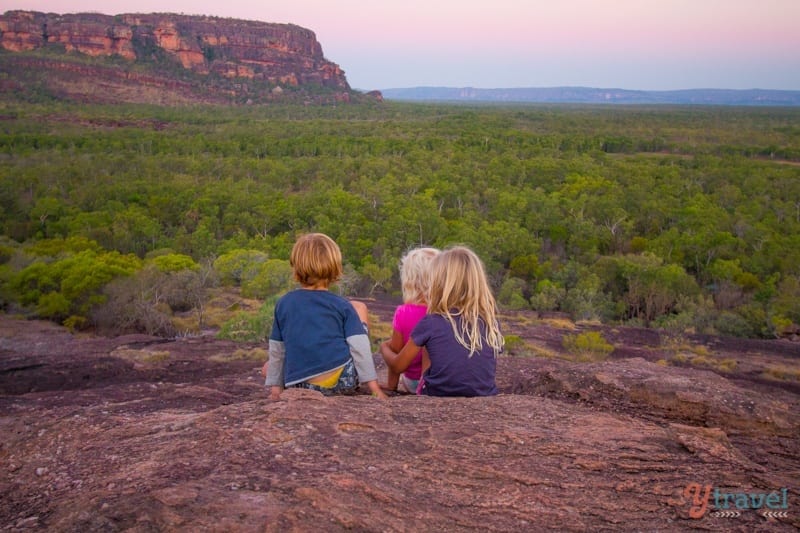 children sitting on rock looking at Sunset at Kakadu National park, Australia