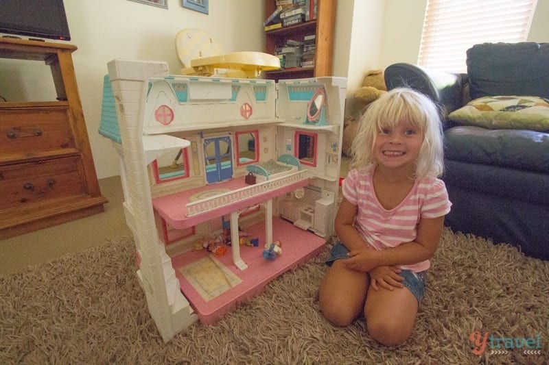 little girl playing with a dollhouse