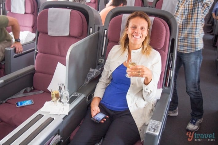 woman sitting in Qantas Business Class flight with champagne