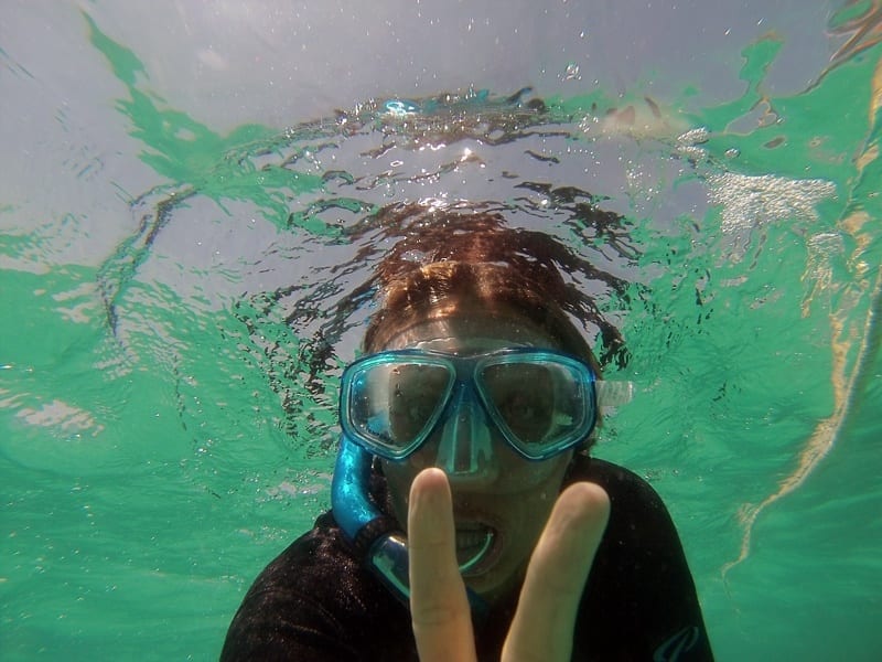 caroline snorkeling giving a peace sign to the camera