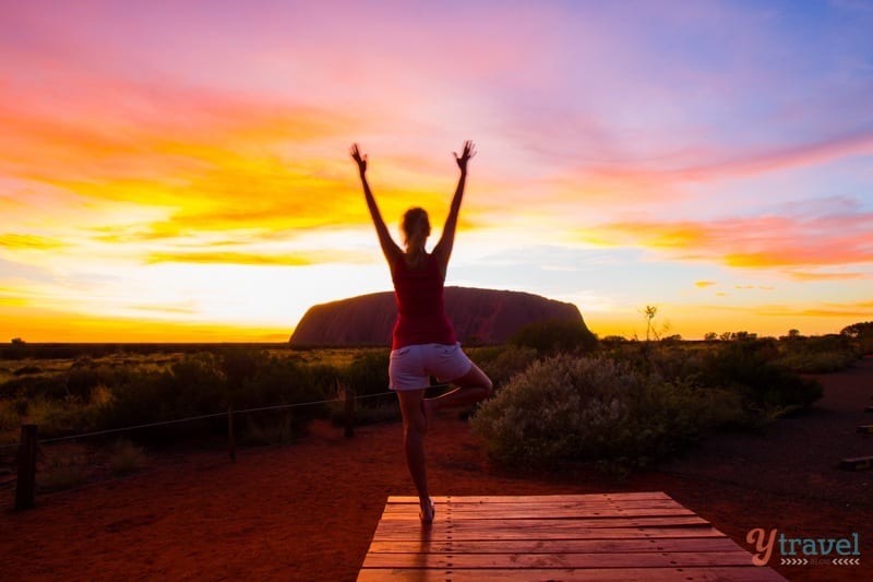woman doing Yoga during sunrise at Uluru 