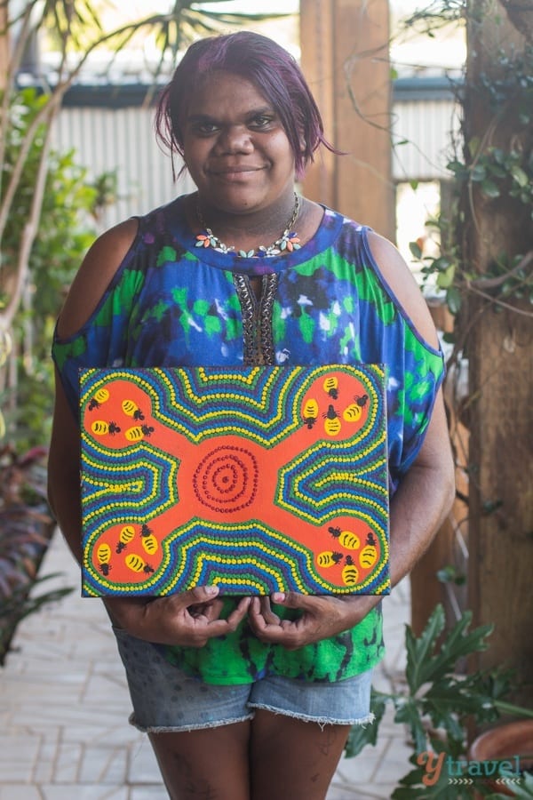 a woman holding a piece of artwork