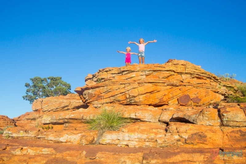 girls standing on a tall rock
