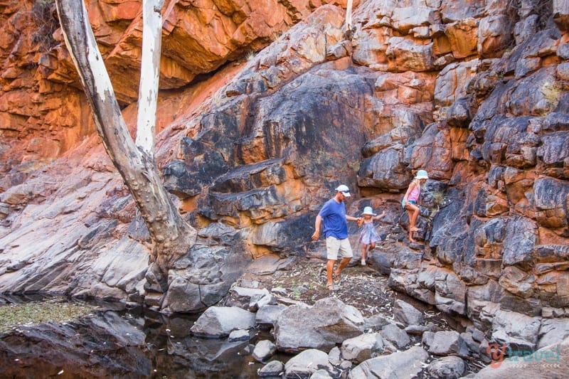 people walking on rocks in a canyon
