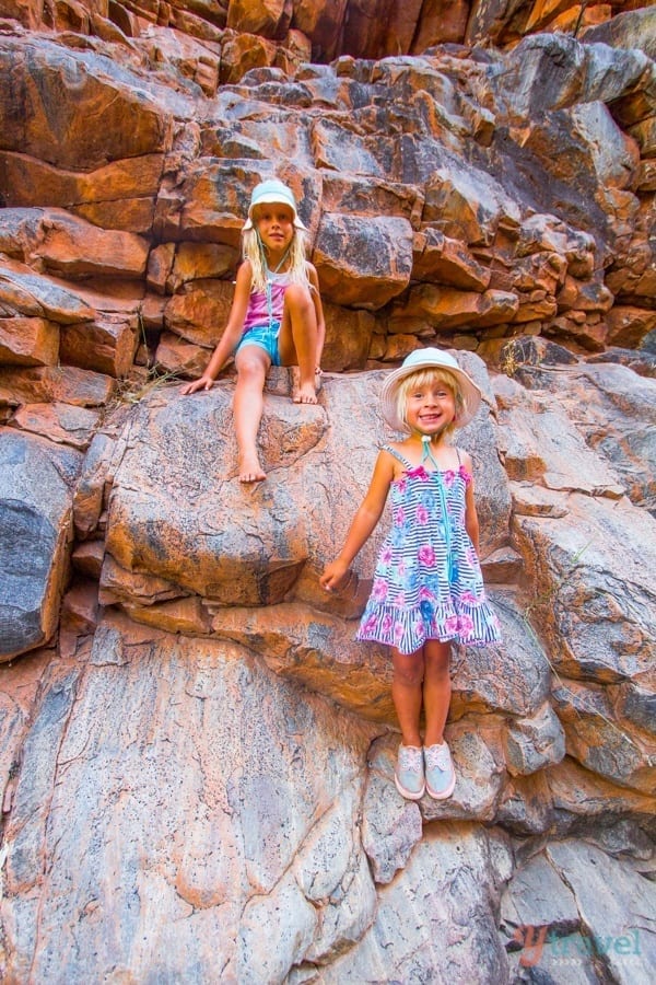 girls climbing up rocks in a canyon