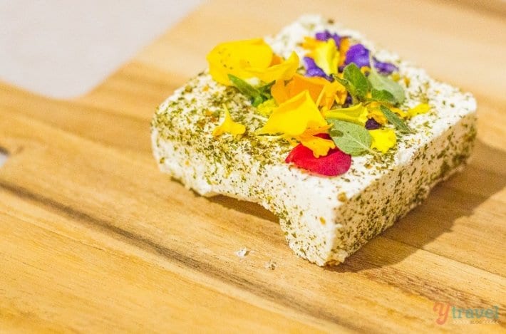 block of cheese with herbs and flowers ont op