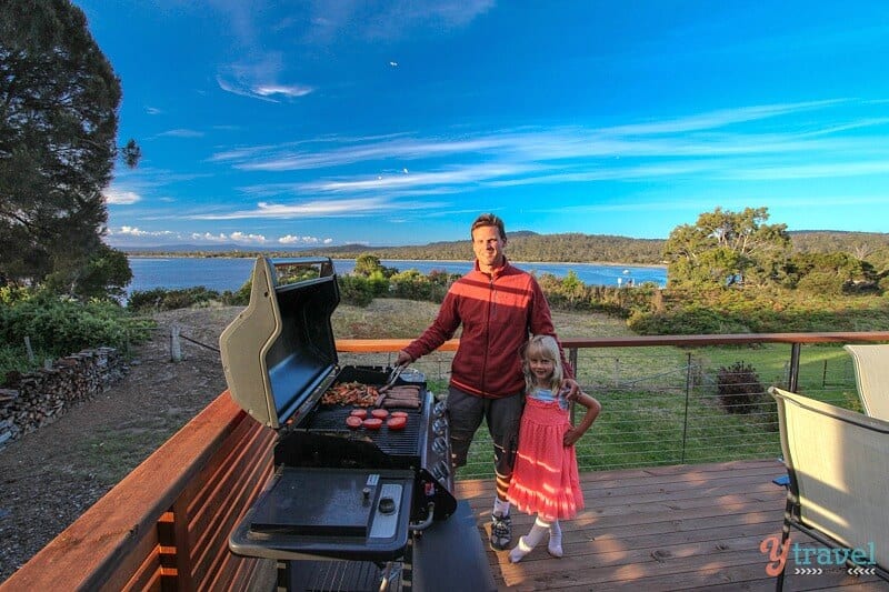 man and child cooking bbq on deck