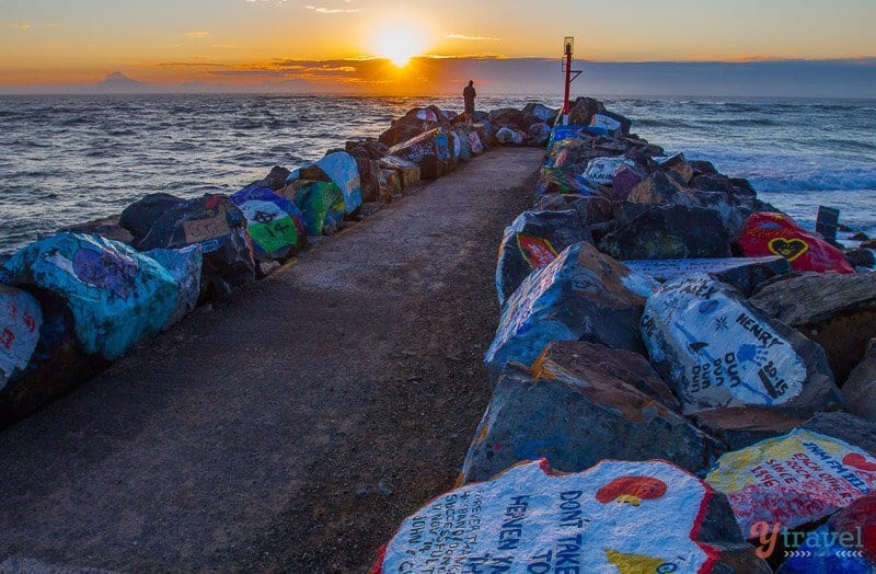 grafitti painted rocks on Port Maquarie rockwall with sunset in background