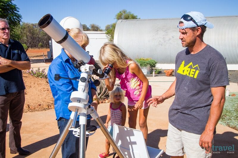 girl looking into telescope 