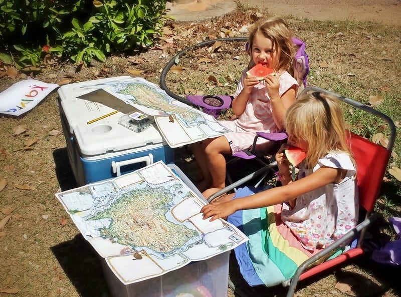 kids looking at maps and eating fruit