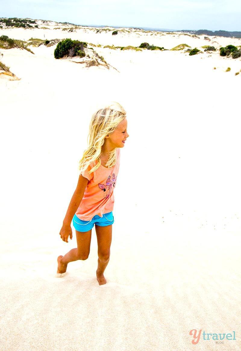 girl playing on a sand dune