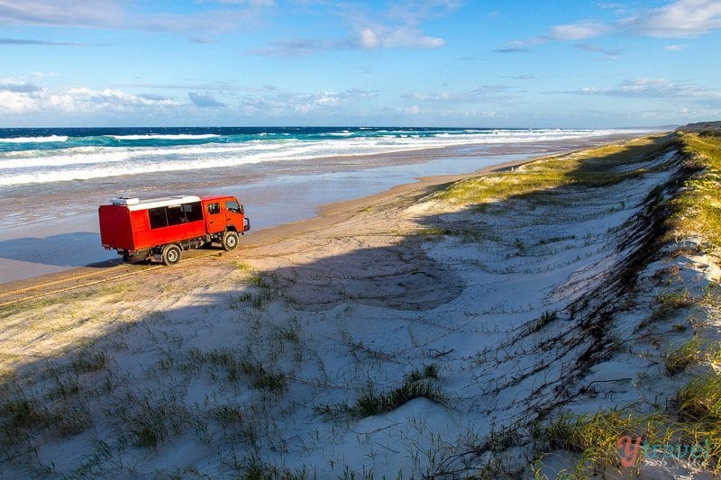 red truck driving on beach