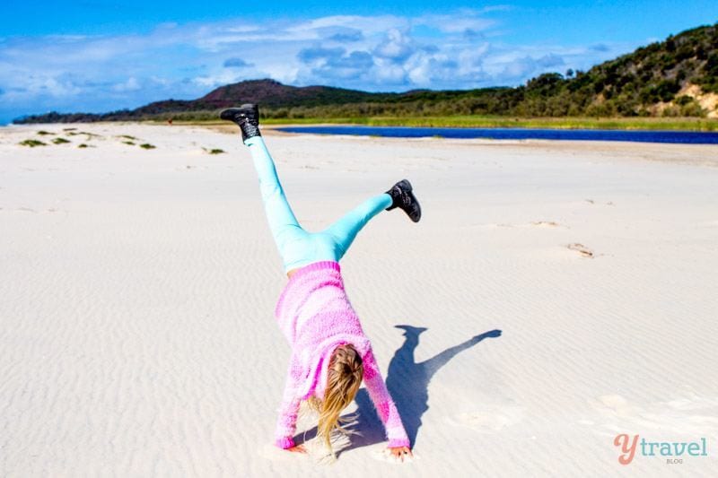 girl doing a cartwheel on the beach