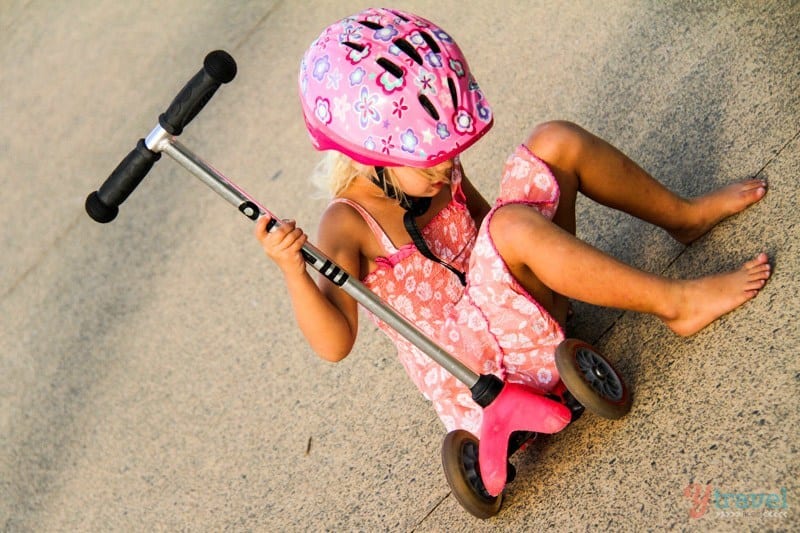 little girl sitting on a scooter
