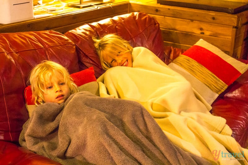 kids lying on a couch with blankets