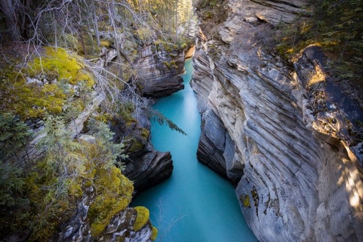 turquoise water running through slot canyon