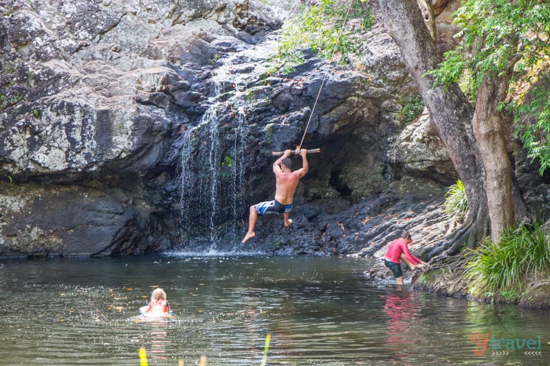 man swinging into water