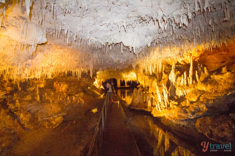 path going through limestone cave under stalagmites
