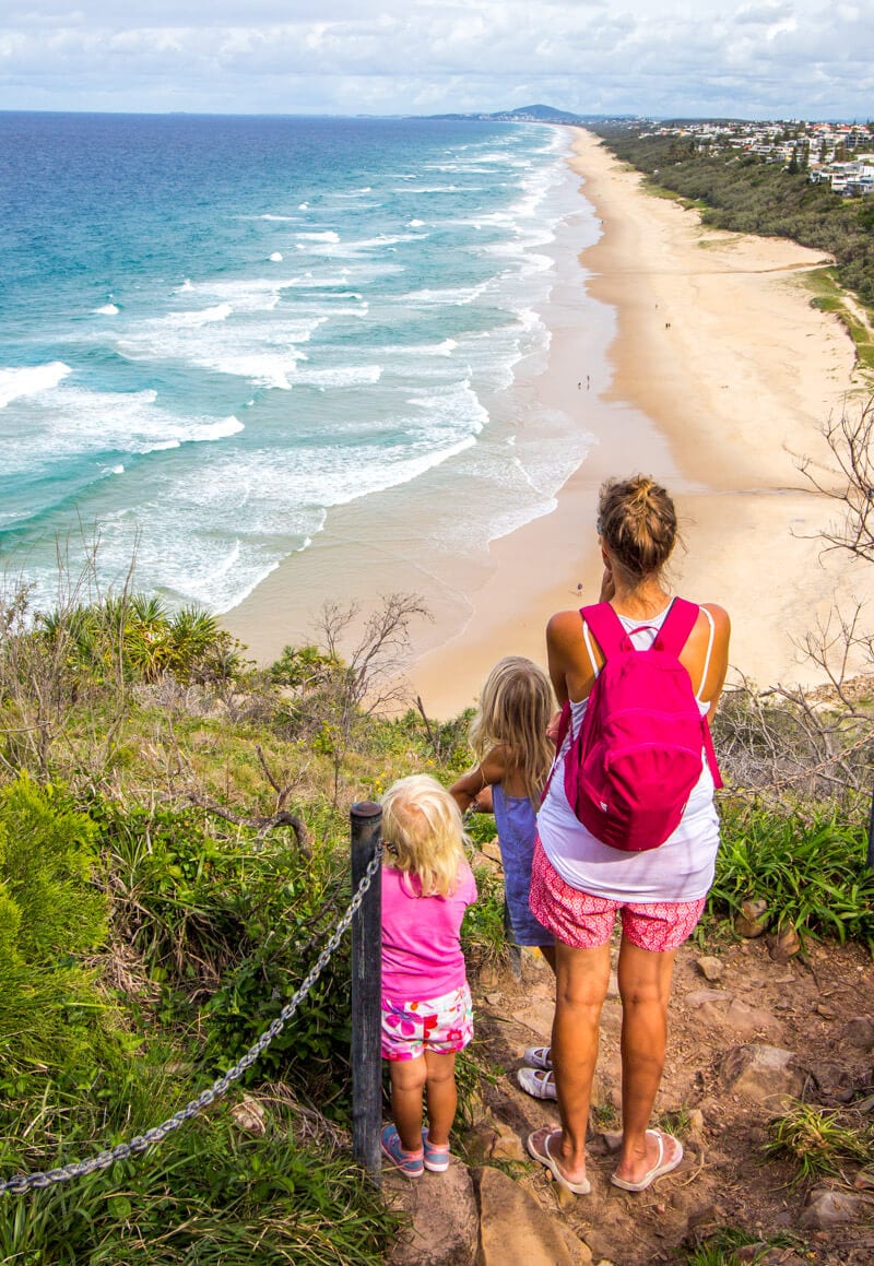 woman and girl looking at view of beach from lookout in noosa national park