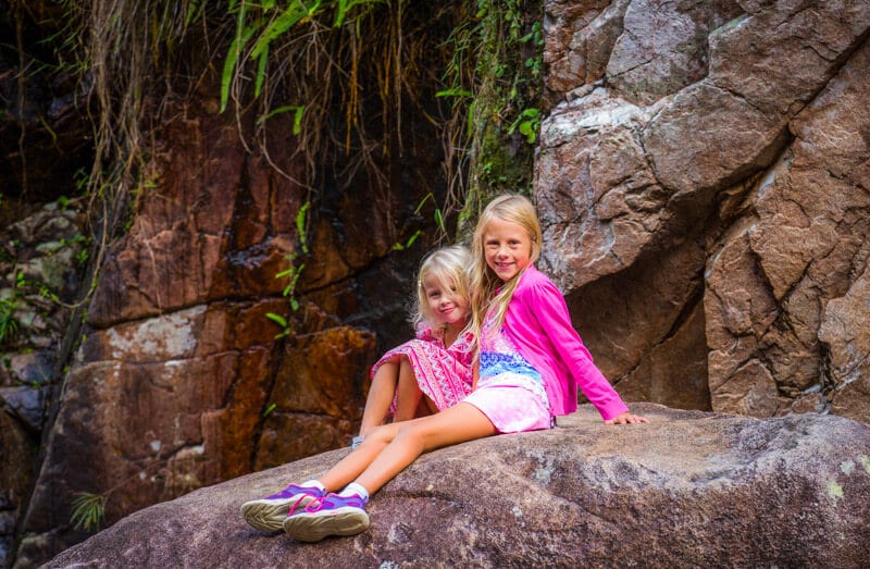 sisters posing on a rock