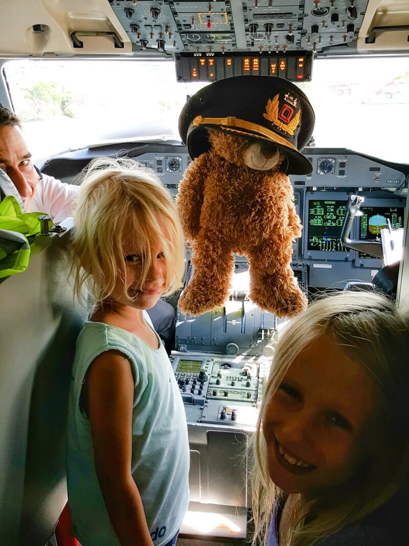 young girl with pilot and teddy bear with hat on