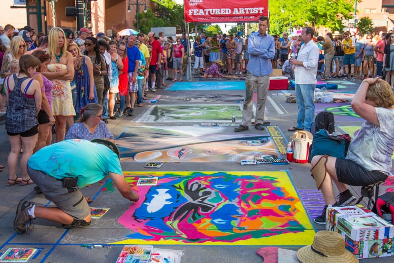 people drawing with chalk on the pavement at the Chalk art festival Denver