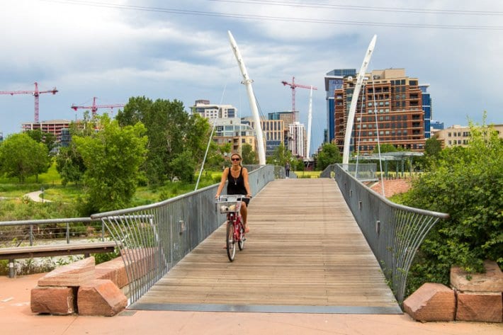 caz riding bike over a bridge in Denver 