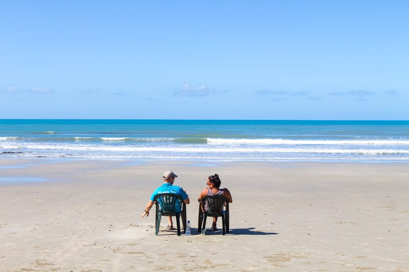 people sitting on chairs on the beach