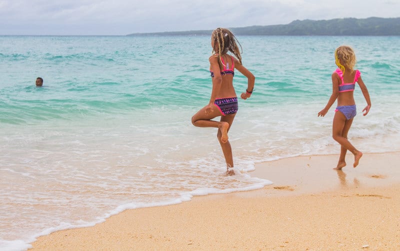girls playing on edge of water Puka Beach is 