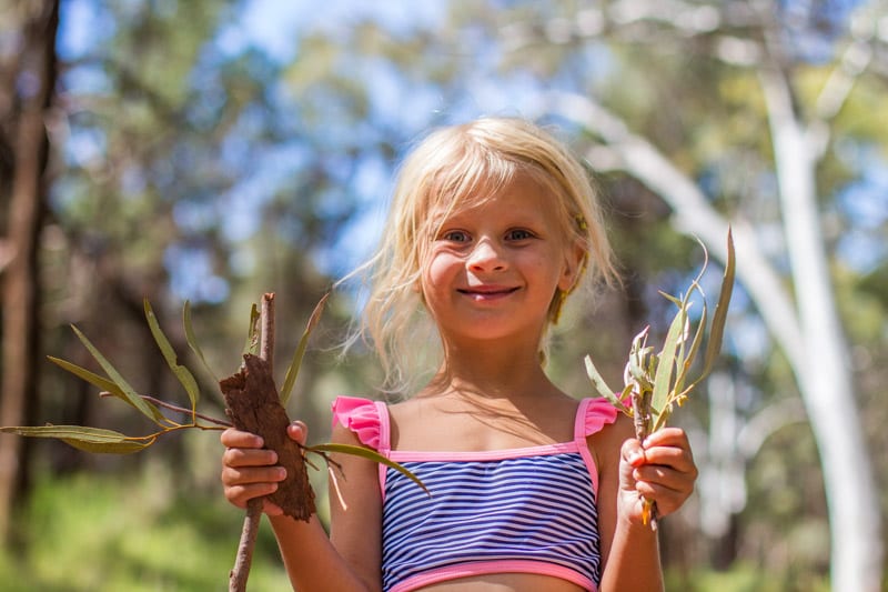 little girl holding up sticks