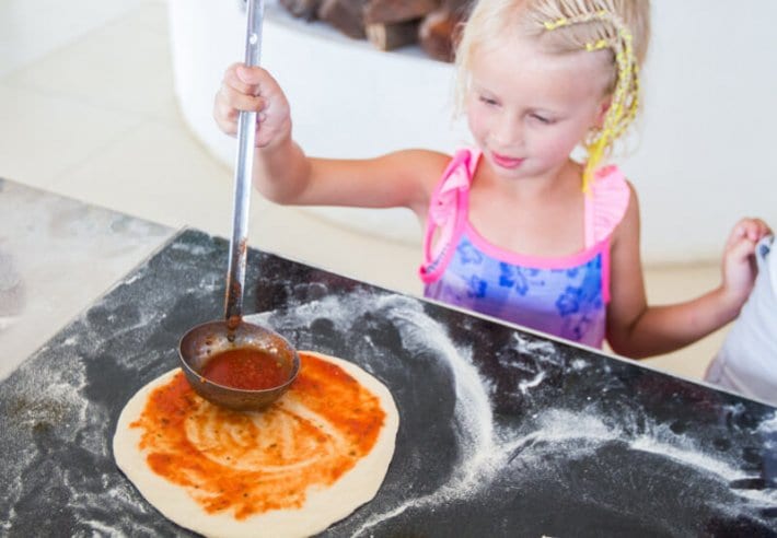 little girl making a pizza