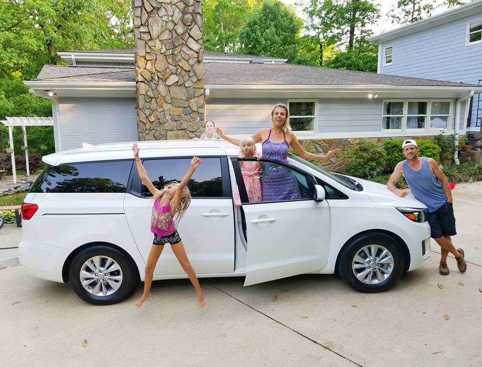 makepeace family jumping beside mini van
