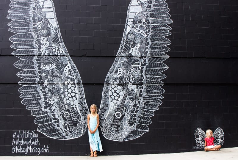 young girls posing against Angel Wings in The Gulch, Nashville