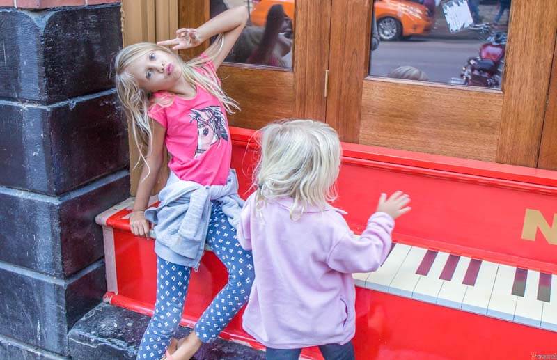 girls playing piano on street