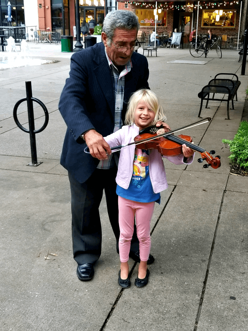 man teaching girl to play violin