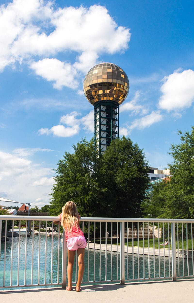 girl looking at golden mirrored ball of the The Sunsphere