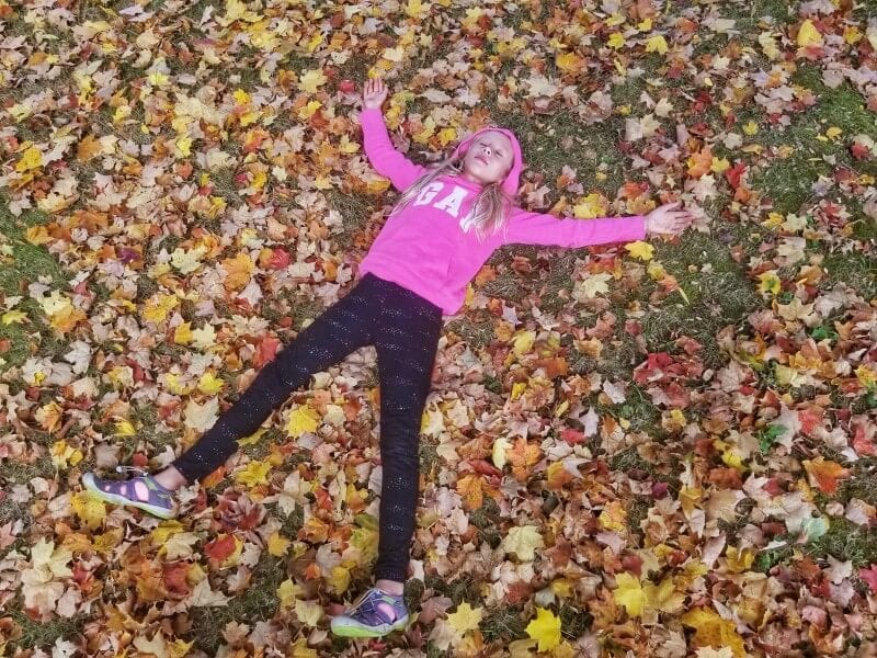 girl lying in fall leaves