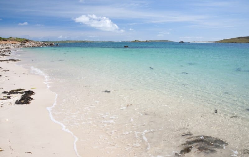 turquoise waters of a white sandy beach on Scilly Isles Uk 