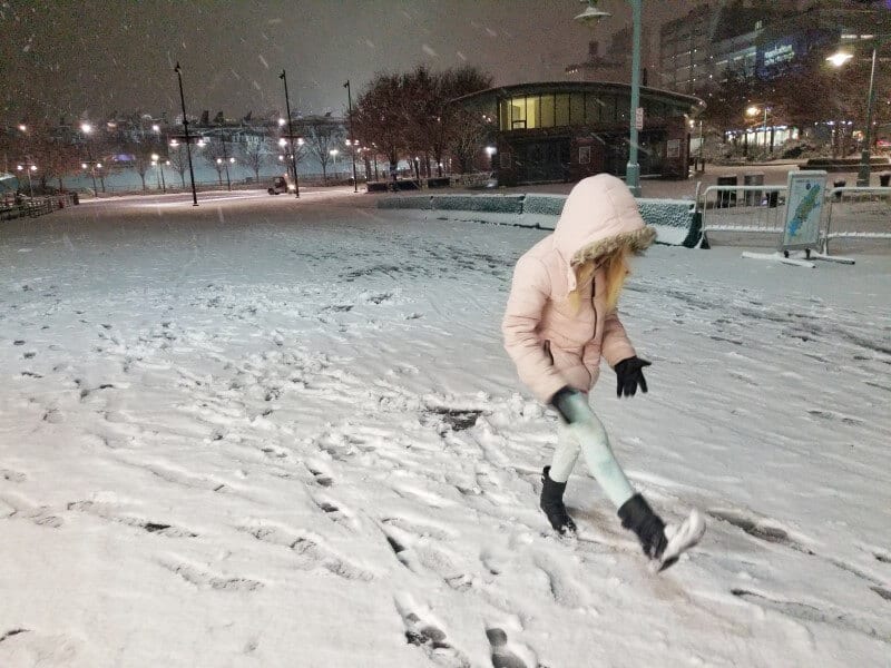 girl playing in the snow in New York City