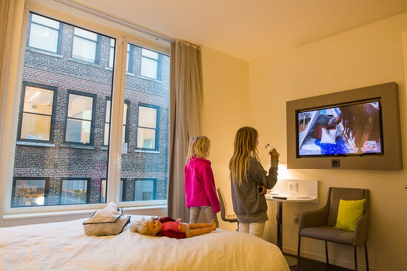 two girls watching TV in hotel room