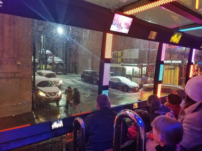 people looking out bus windown in NYC on the The Ride Experience 