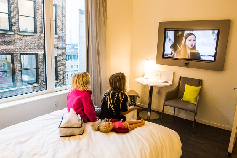 girls watching TV inside hotel room
