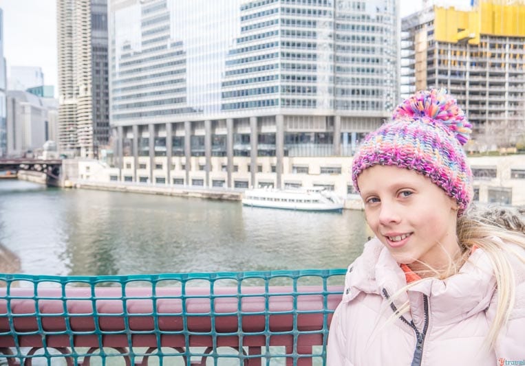 girl smiling at camera in beanie in front of chicago river
