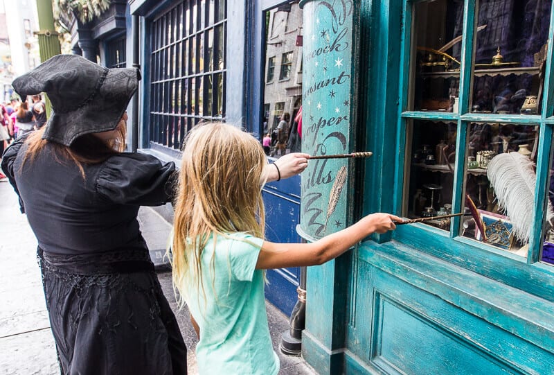 girl and witch holding wands up to window Universal Orlando