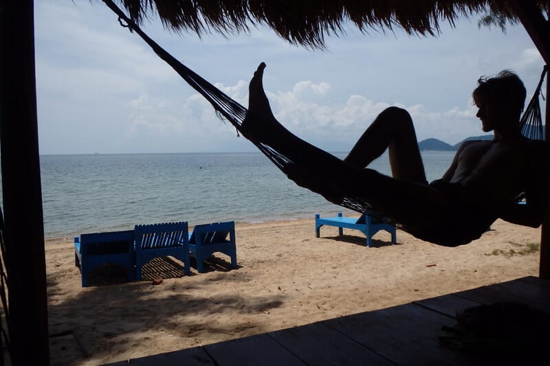 man swinging on hammock at beach