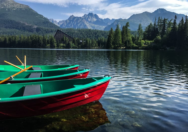 boats in a lake with mountains in the background